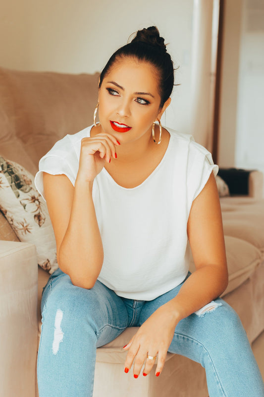 Femme en chemise blanche et jean portant des créoles, look casual décontracté et élégant