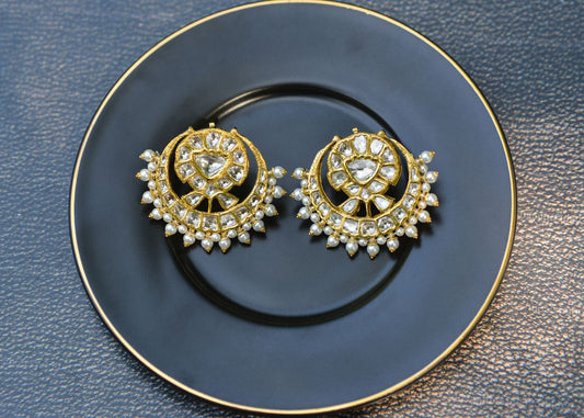 Boucles d'oreilles dorées et perlées élégamment présentées