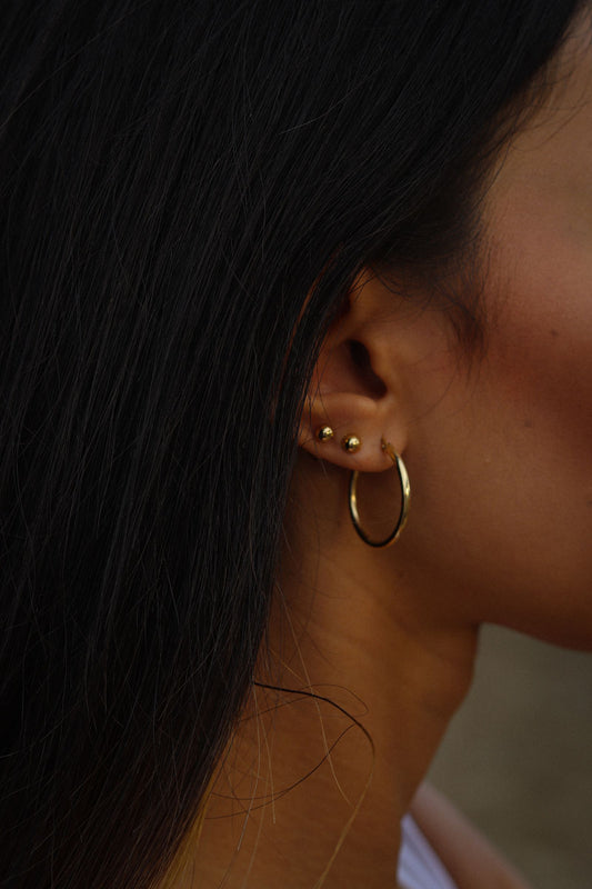 Gros plan sur des boucles d'oreilles portées par une femme