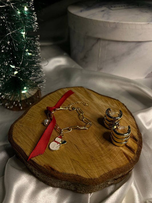Bijoux dorés présentés sur bois avec rubans, ambiance cadeau de Noël élégante