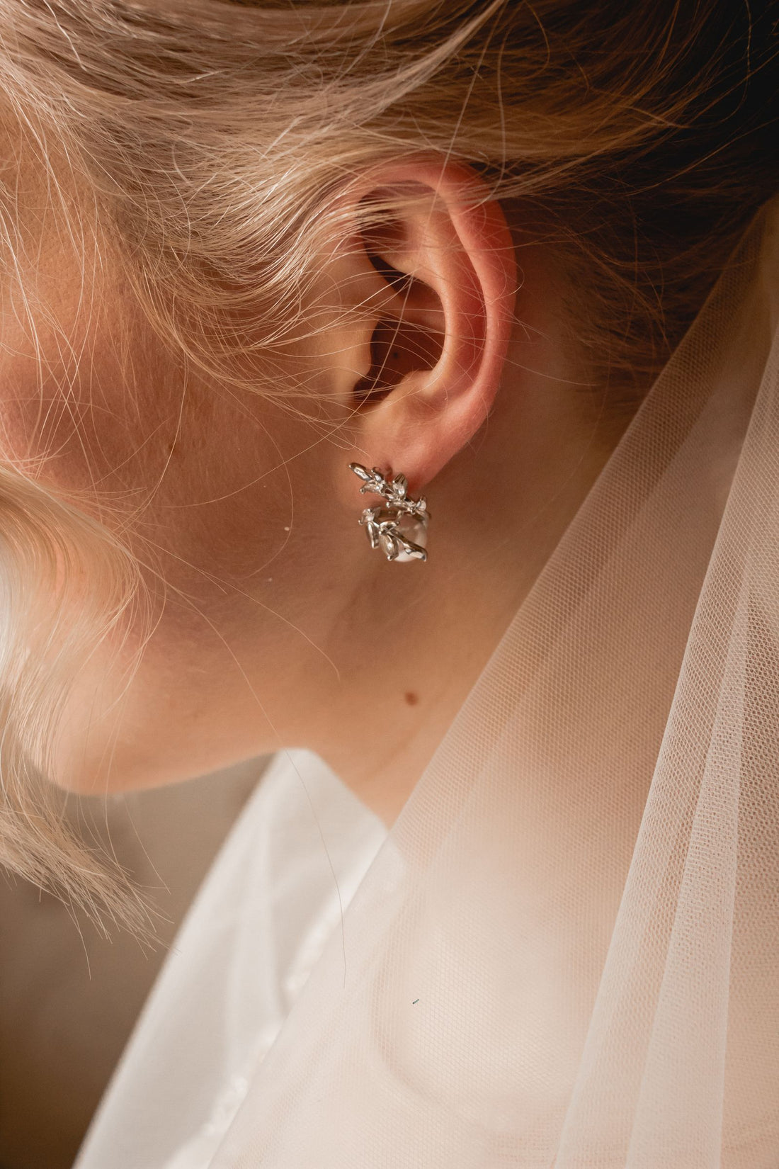 Gros plan sur des boucles d'oreilles en cristal portées pour un mariage