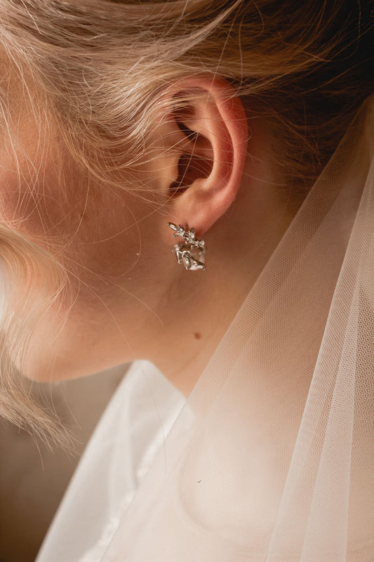 Gros plan sur des boucles d'oreilles en cristal portées pour un mariage