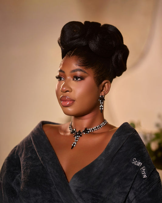 Femme avec un chignon élégant portant des boucles d'oreilles visibles, illustrant l'association entre coiffure et bijoux