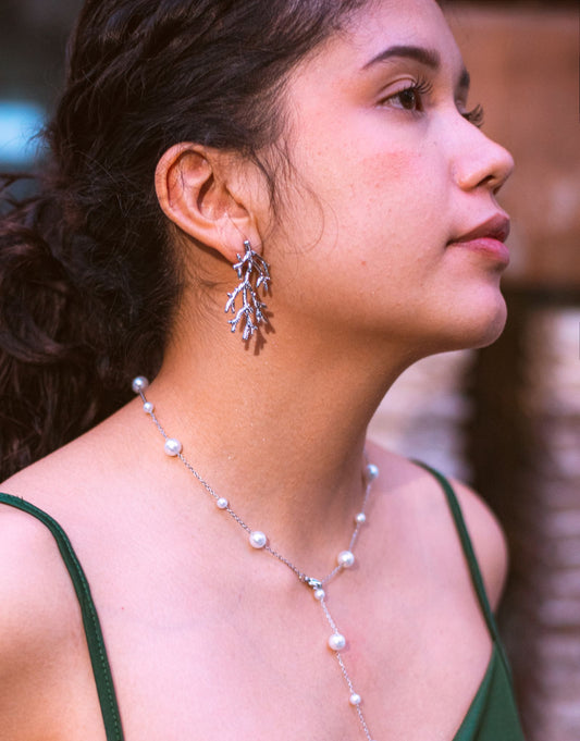 Profil d'une femme mettant en valeur son cou avec d'élégantes boucles d'oreilles argentées