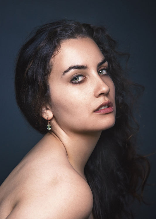 Femme aux cheveux longs et bruns portant d'élégantes boucles d'oreilles