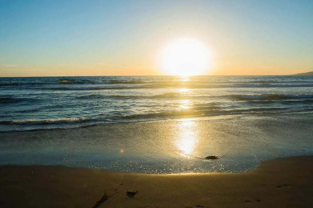 soleil tombant jaune sur plage eau bleue