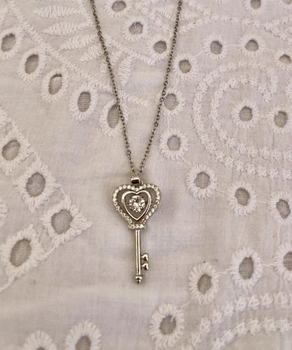 Collier-couleur-argent-avec-pendentif-en-forme-de-clef-coeur -fond-blanc